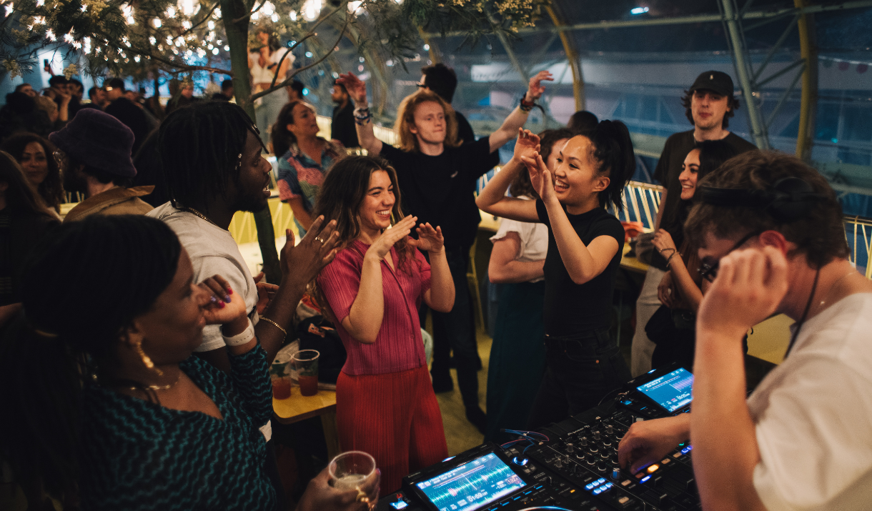 People dancing with a DJ at Design District Canteen on Greenwich Peninsula